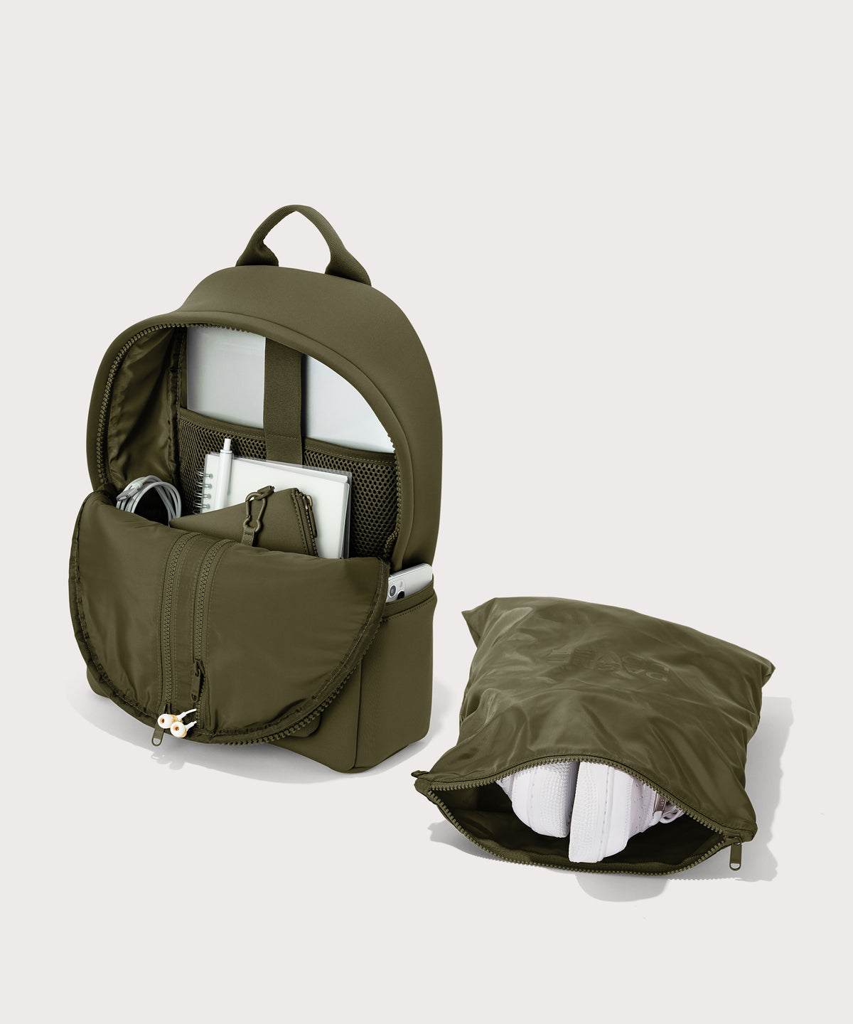 Dagne Dover medium Dakota Neoprene Backpack in dark moss unzipped, showing the interior pockets and shoe bag.