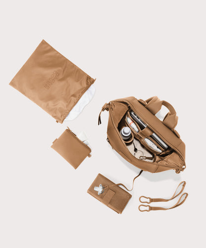 Dagne Dover Medium Indi Diaper Backpack in camel brown showing it's water resistant bag, interior pockets, and changing mat.