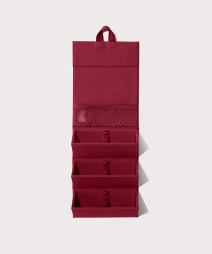 Dagne Dover Remi foldable glasses holder in spice red hung up.